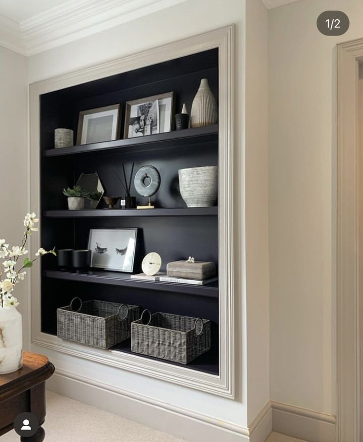 Bespoke dark inset shelving framed by traditional mouldings