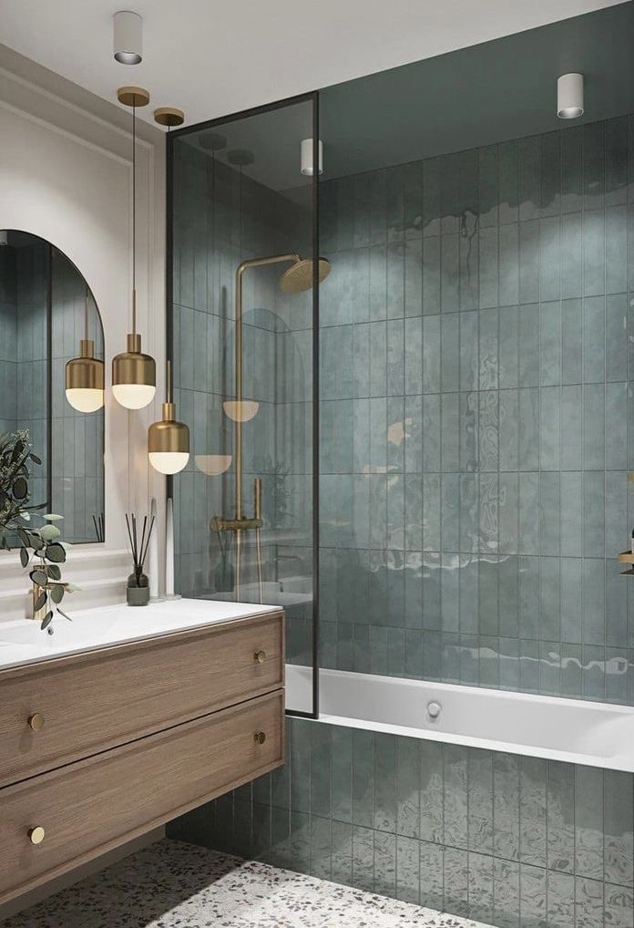 Bathroom with glazed green tiling, aerated brushed-brass shower and a timber vanity