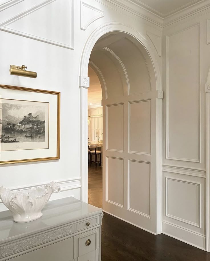 Arched opening framed by carefully proportioned wall panelling and original-style mouldings